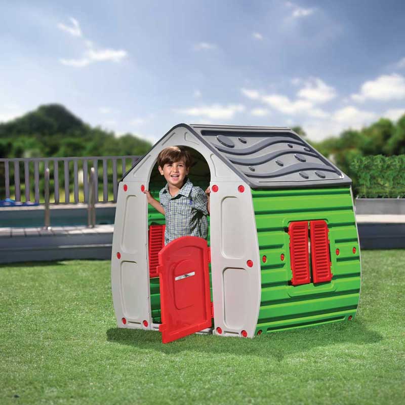 Детска пластмасова къщичка за игра на двора Magic Playhouse – дете играе на входа на къщичката.